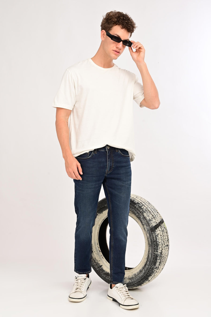 Model wearing IVYN Arden Deep Indigo Wash ankle-fit jeans with a white T-shirt