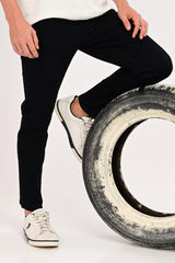 Lifestyle detail of IVYN Arden Jet Black ankle-fit jeans styled with white sneakers
