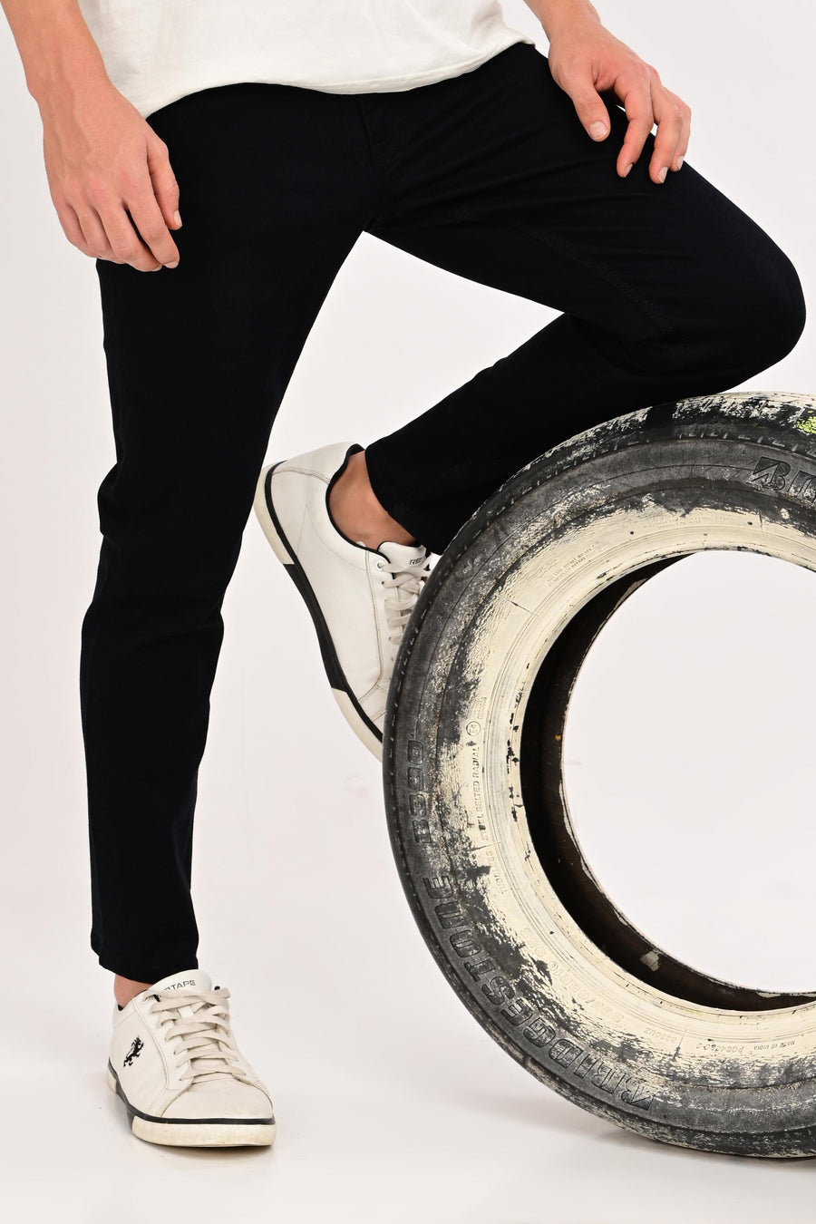 Lifestyle detail of IVYN Arden Jet Black ankle-fit jeans styled with white sneakers