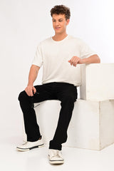 Model wearing IVYN Camden Jet Black straight-fit jeans in a seated studio look