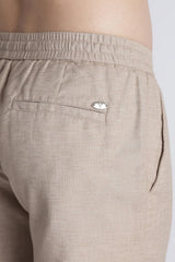 Back pocket and IVYN metal badge detail on mushroom taupe trousers