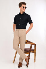 Model wearing IVYN Regent mink beige slim-fit formal trousers with a black shirt
