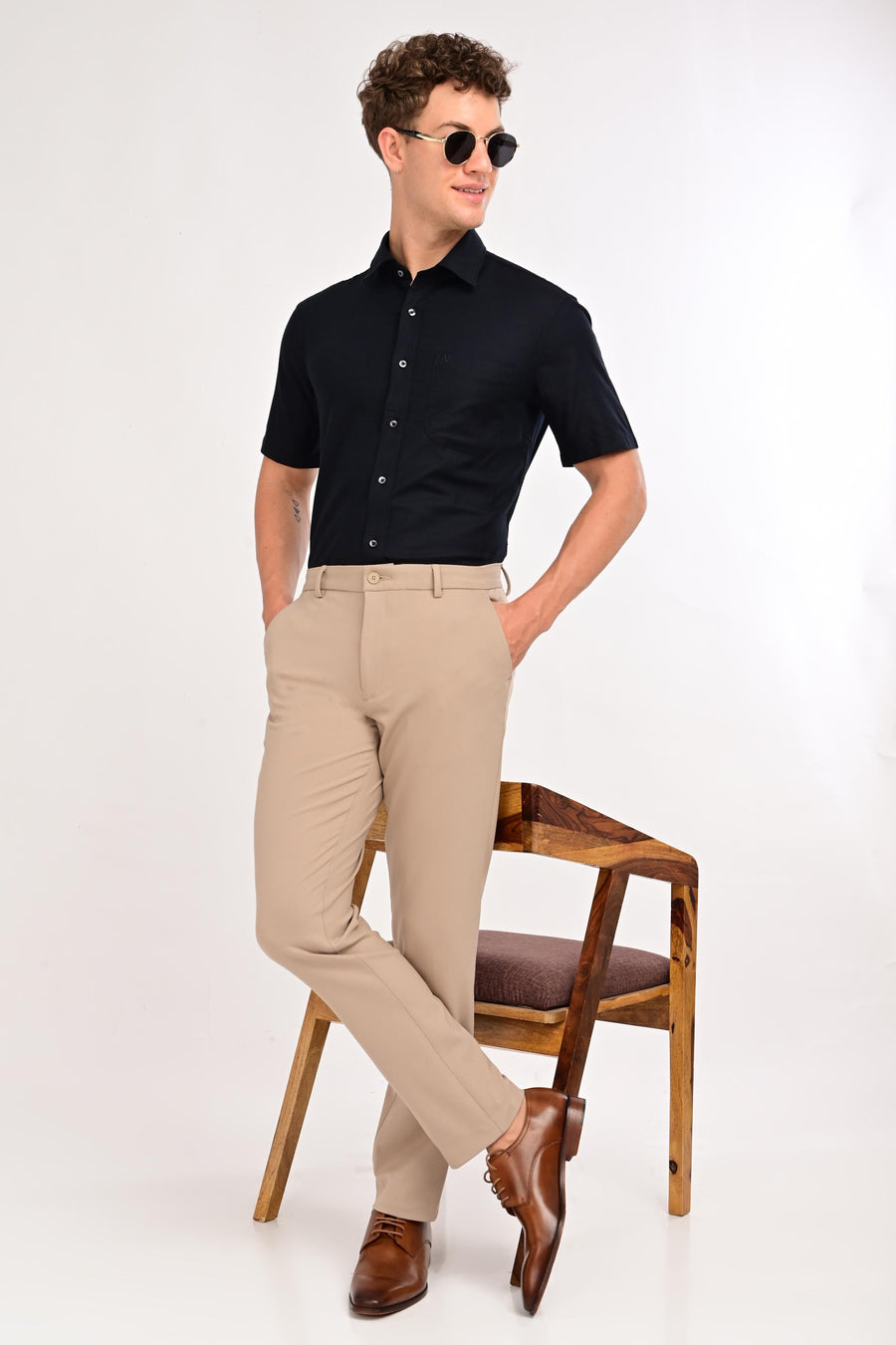 Model wearing IVYN Regent mink beige slim-fit formal trousers with a black shirt