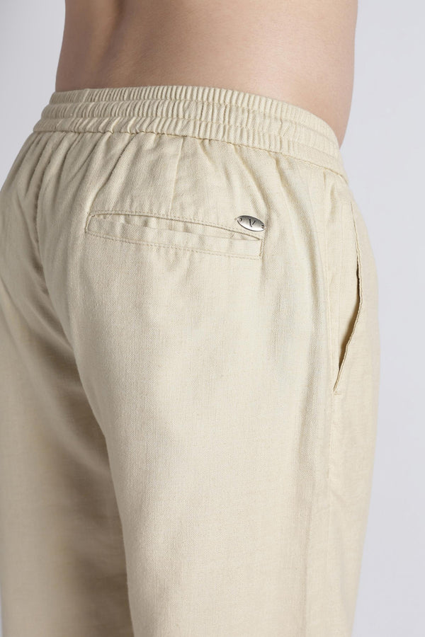 Rear welt pocket and IVYN metal badge detail on soft cream trousers